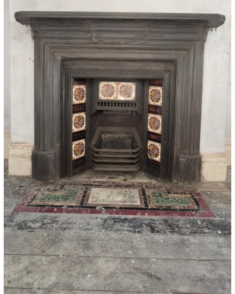 Cast-iron fireplace stripped to reveal original tiles