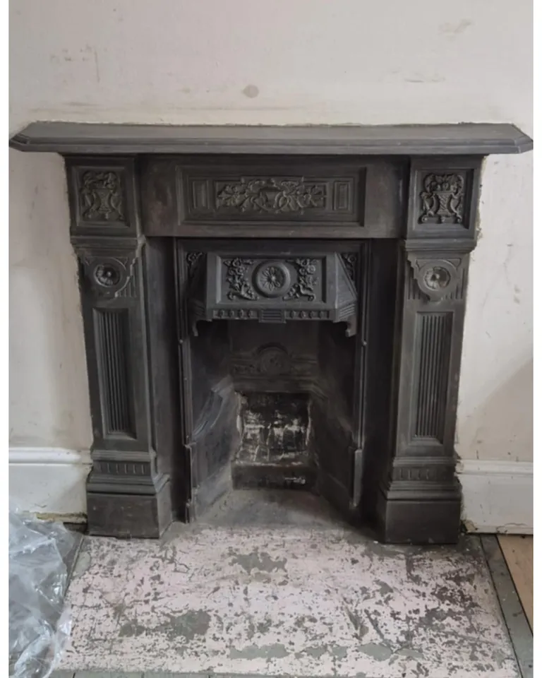 The same fireplace after stripping, revealing the bare cast iron